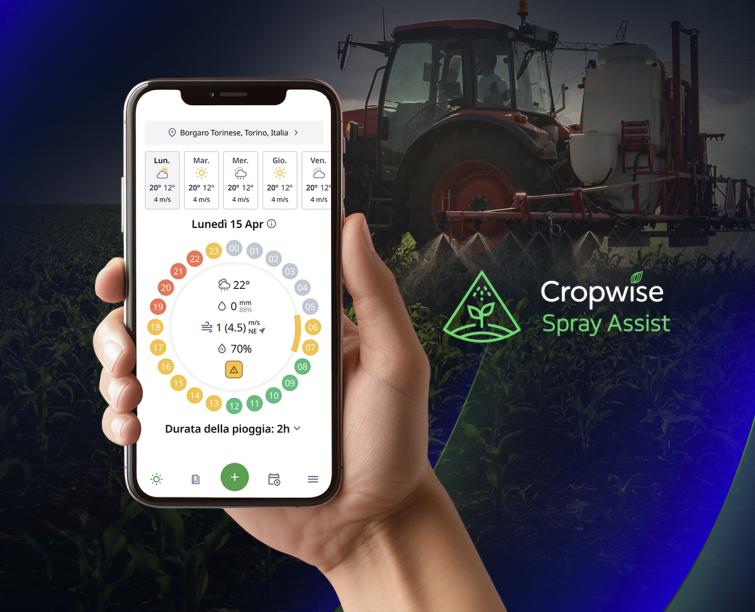 Mano con smartphone che mostra app agricola; sullo sfondo trattore e testo “Cropwise Spray Assist”.